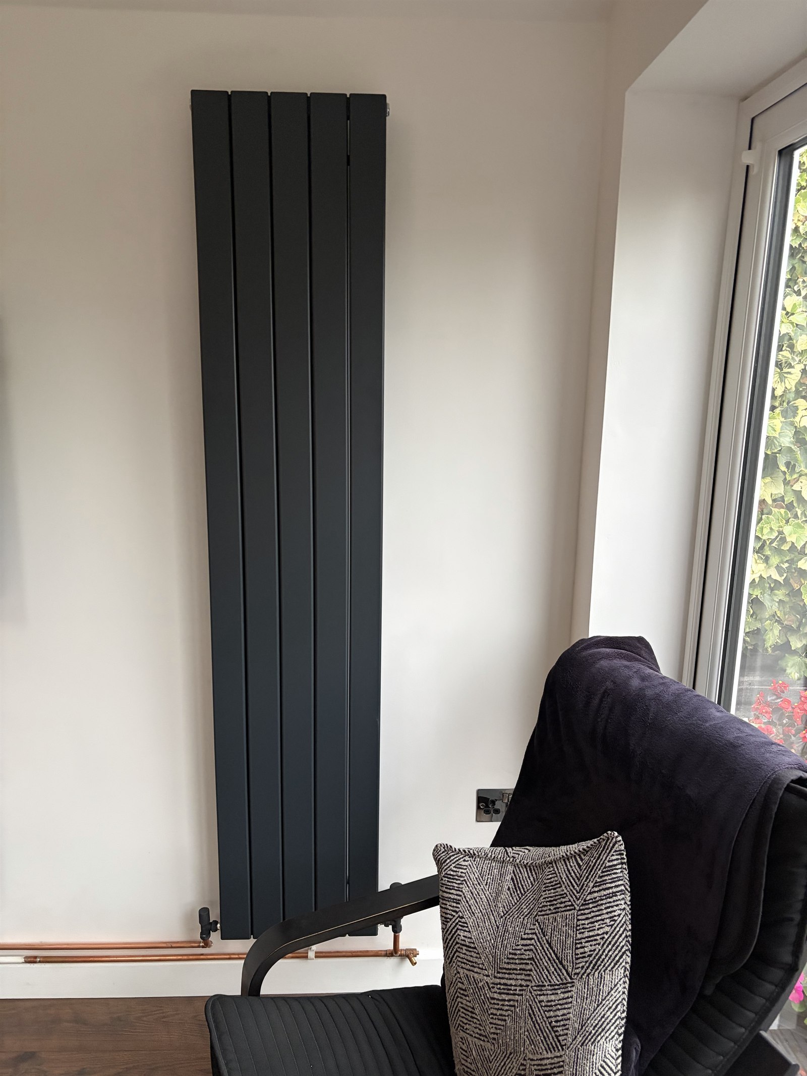Second view of a black vertical designer radiator fitted in an Enderby home
