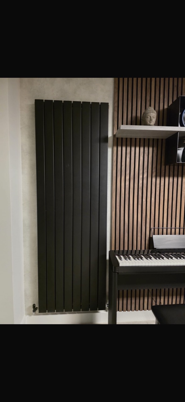 Black vertical designer radiator fitted at a Leicester city-centre property