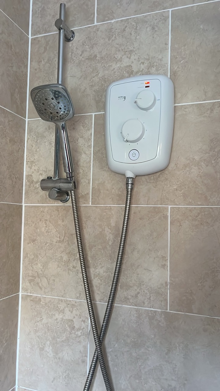 Old electric shower before replacement after its temperature began changing between hot and cold in Wigston