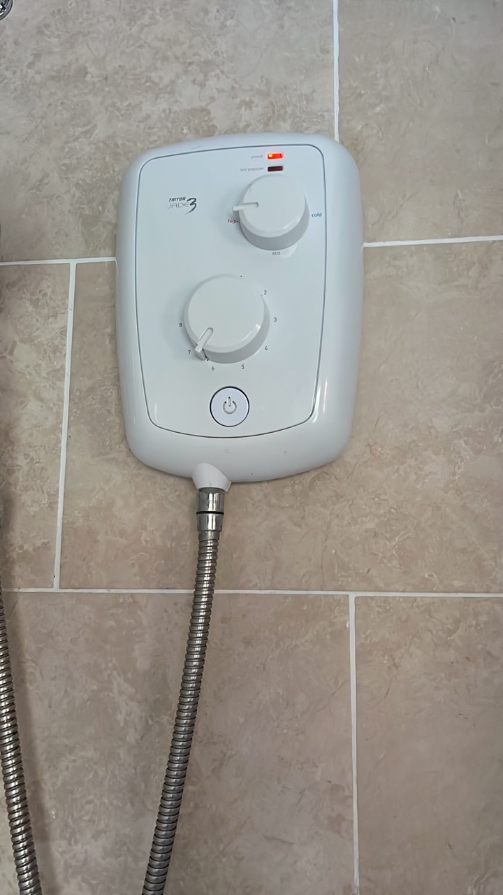 Faulty old electric shower removed during a next-day replacement in Wigston